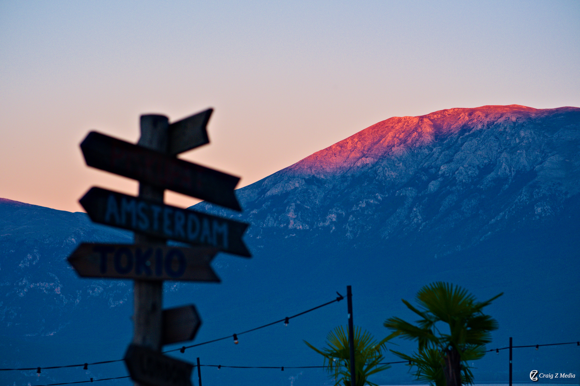 The Pogradec lakefront sign glowing in the warm evening light — the promenade comes alive at dusk